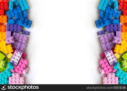 A bunch of Multicolor Plastick constructor bricks on white background. Popular toys. Copyspace. Border of A lot of Colorful Plastick constructor bricks on white background. Popular toys. Copyspace. Horizontal