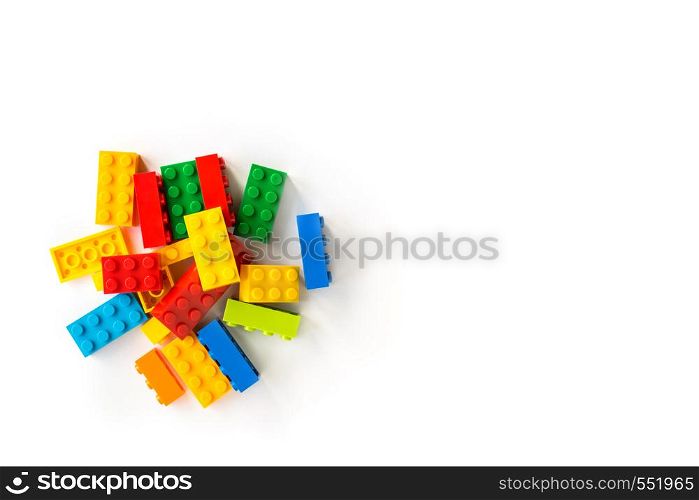 A bunch of Multicolor Plastick constructor bricks on white background. Popular toys. Copyspace. Bunch of Colorful Plastick constructor cubes on white background. Popular toys. Copyspace
