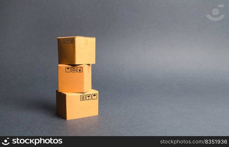 A bunch of three cardboard boxes. The concept of products and goods, commerce and retail. E-commerce, sales and sale of goods through online trading platform. Import and export of products