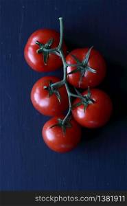 A bunch of tomatoes on a black background