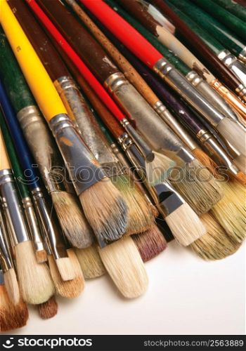 A bunch of used paintbrushes