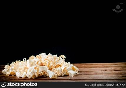 A bunch of wood chips on the table. On a black background. High quality photo. A bunch of wood chips on the table.