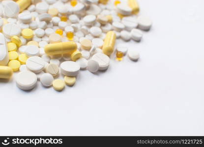 A bunch of yellow and white tablets and pills isolated on a white background close up. Selective focus. Health day. Medical pharmacy concept.Copyspace. A bunch of yellow and white tablets and pills isolated on a white background