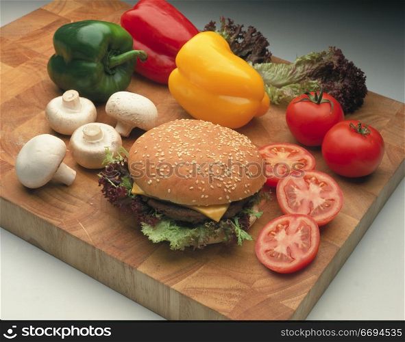 a burger on a bun with salad/vegetable items