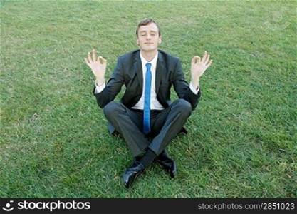 A business man doing yoga in the park