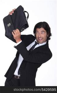 a business man is protecting his face with a briefcase, he looks amused