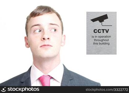 A business man looking sideways at cctv