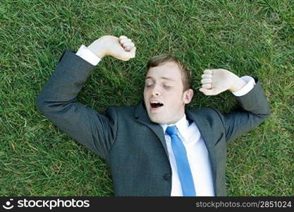 A business man lying on the grass