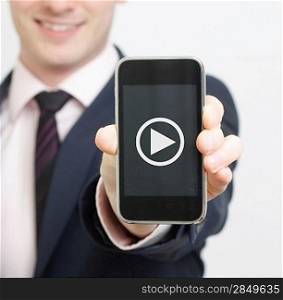 A business man showing his phone with video button