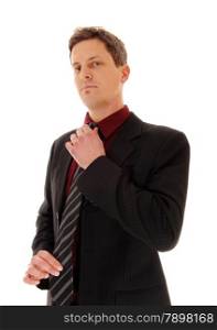 A business man standing in a suit and fixing his tie, looking serious,isolated for white background.