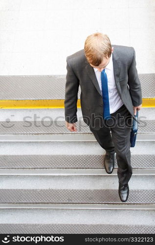 A business man walking down some steps