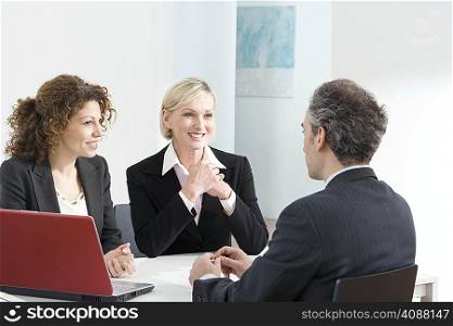 A business meeting with a red laptop
