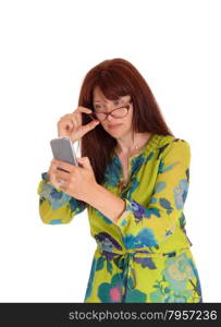 A business woman in a colorful dress holding her glasses and looking ather cell phone, isolated for white background.