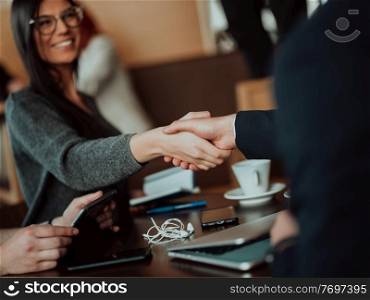 a businessman and a businesswoman are shaking hands in office. Collaborative teamwork.. a businessman and a businesswoman are shaking hands in office.