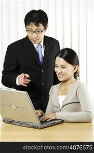 A businessman and a businesswoman working in an office