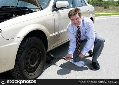 A businessman demonstrating how to use a jack to change a tire.