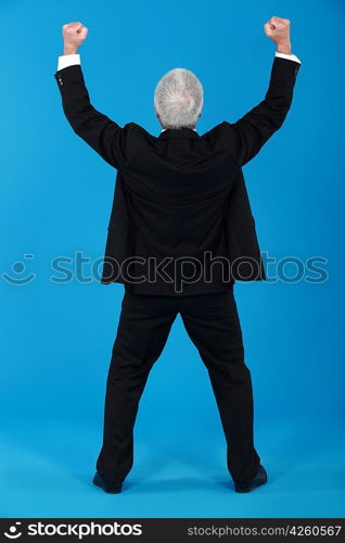 A businessman gesturing a victory sign.