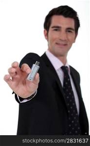 A businessman handing a USB key.
