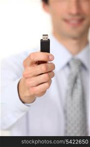 A businessman handing a USB key.