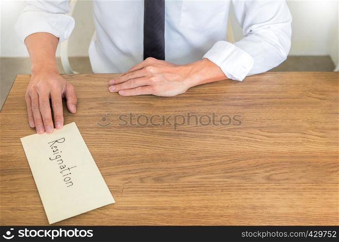 A businessman handing and sending in a envelope letter on a wooden table to his boss, Change of job, unemployment concept.