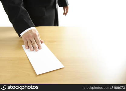 A businessman handing in a blank envelope