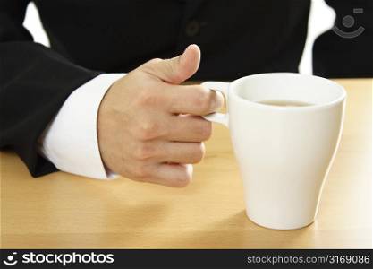 A businessman holding a cup of coffee