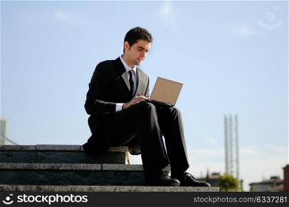 A businessman holding a laptop computer