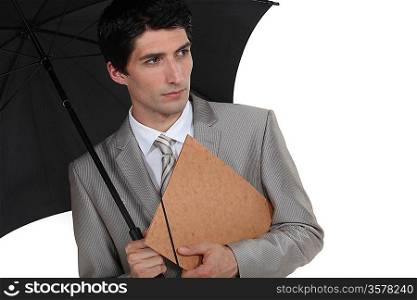 A businessman holding an umbrella.