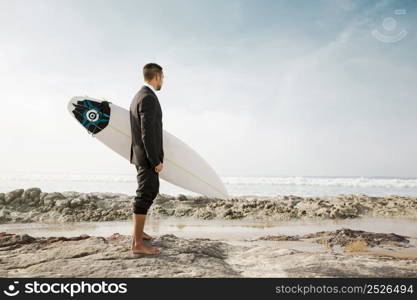 A Businessman holding is surfboard after a long day of work