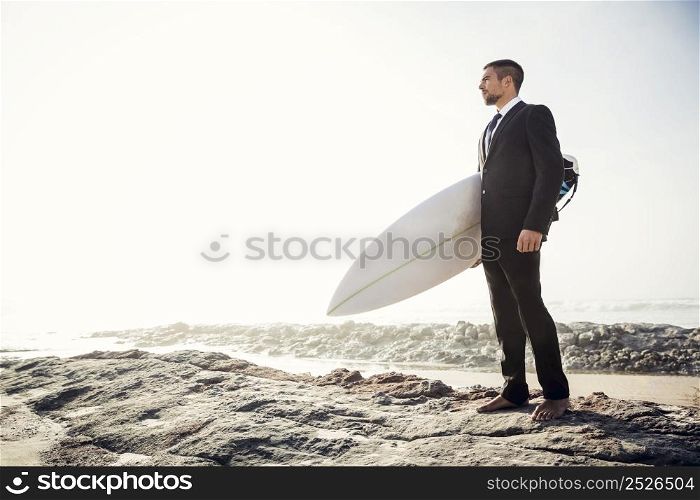 A Businessman holding is surfboard after a long day of work