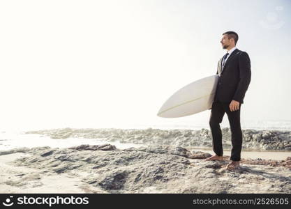 A Businessman holding is surfboard after a long day of work