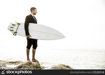 A Businessman holding is surfboard after a long day of work