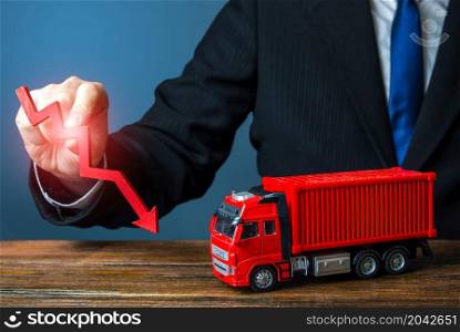 A businessman holds a red arrow down and a truck. Low sales. Production decline. Import, export. End of global containers shortage crisis. Transportation inflation, shipping rates. Priced drop