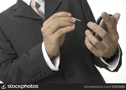 a businessman in grey suit uses an electronic organiser