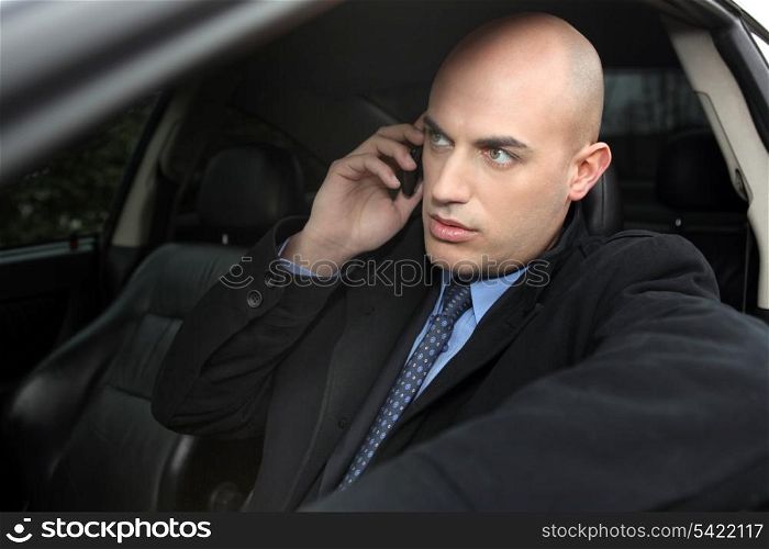 A businessman in his car over the phone.