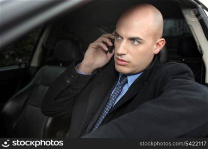 A businessman in his car over the phone.