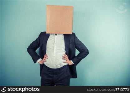 A businessman is standing around proudly with a cardboard box on his head