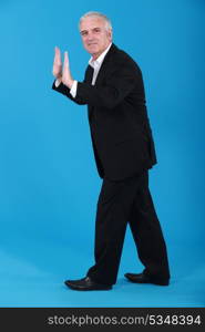 A businessman making a push gesture.
