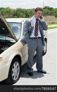 A businessman on the road with a flat tire. He&rsquo;s calling his next appointment to say he will be late.
