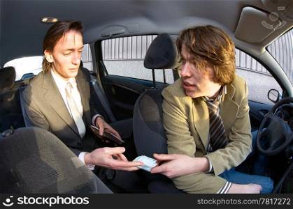 A businessman paying the fare to the taxi driver