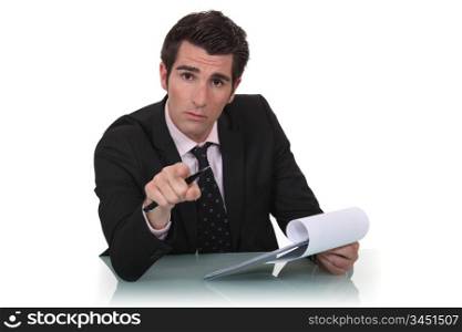 A businessman pointing at the camera.