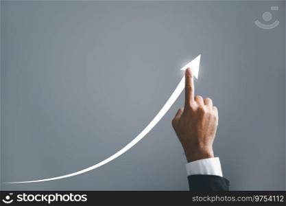 A businessman pointing hand guides an arrow on a graph, illustrating the corporate future growth plan. the concept of business development, growth, and the journey to success.. A businessman hand confidently guides an arrow on a graph