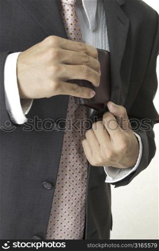 a businessman produces his wallet from his inside jacket pocket
