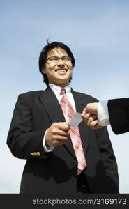 A businessman receiving a business card from his business partner