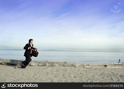 A businessman running on the beach carrying a cup and a bag