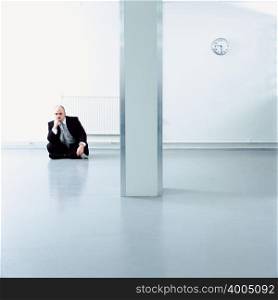 A businessman sat on a floor