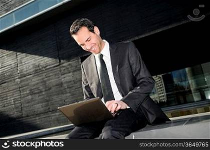 A businessman sitting on the floor with a laptop computer
