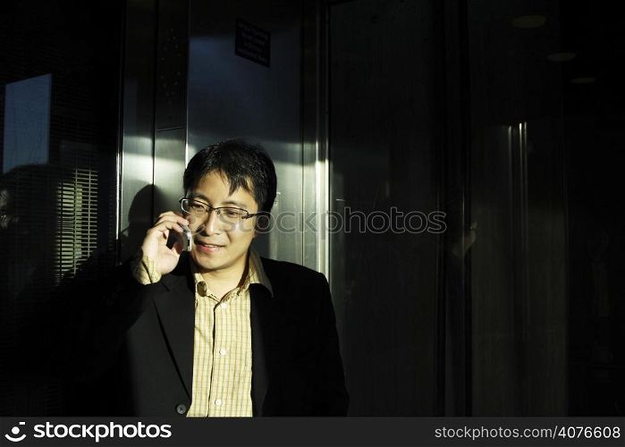 A businessman talking on the phone at the elevator