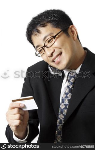 A businessman talking on the phone while holding credit card