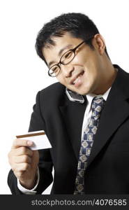 A businessman talking on the phone while holding credit card